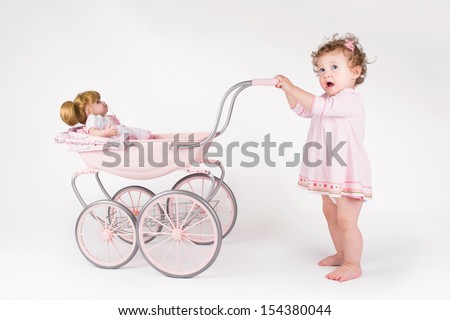 Funny Baby Girl Walking With A Doll Stroller
