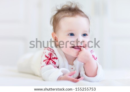 Sweet little baby wearing a knitted sweater with red Christmas ornament Sweet little baby wearing a knitted sweater with red Christmas ornament