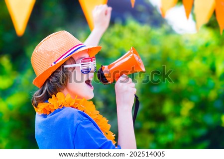 Happy Dutch boy, football fan, cheering and supporting soccer team of Netherlands during championship, celebrating sports victory screaming Hup Holland in a megaphone
