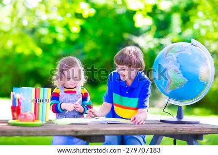 Children in school yard. Kids studying. Happy laughing teenager student boy and preschool girl in the school garden reading books and having apple for healthy snack, back to school concept