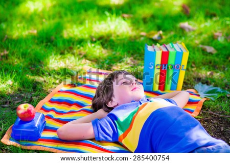 Child in school yard. Smart teenager student boy studying and learning outdoors, reading books and having apple for healthy snack. Kids happy to be back to school. Children in a class.