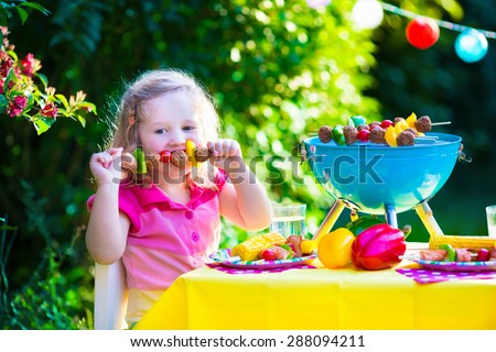 Children grilling meat. Family camping and enjoying BBQ. Little girl at barbecue preparing steaks, kebab and corn. Kids eating grill and healthy vegetable meal outdoors. Garden party for toddler child