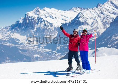 Happy mature couple skiing in the Alps mountains. Senior man and woman enjoying ski vacation in alpine resort. Active retirement. Healthy winter sport for every age.