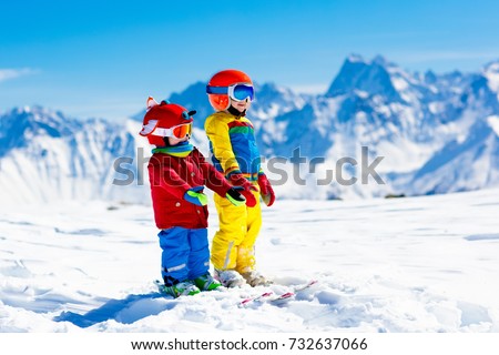 Child skiing in the mountains. Kid in ski school. Winter sport for kids. Family Christmas vacation in the Alps. Children learn downhill skiing. Alpine ski lesson for boy and girl. Outdoor snow fun.