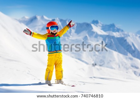 Child skiing in the mountains. Kid in ski school. Winter sport for kids. Family Christmas vacation in the Alps. Children learn downhill skiing. Alpine ski lesson for boy or girl. Outdoor snow fun.