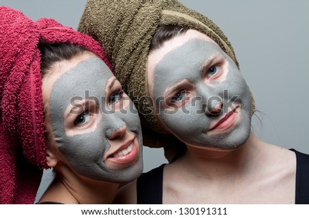 Clay facial mask. Two happy sisters