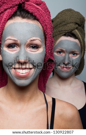 Clay facial mask. Two happy sisters
