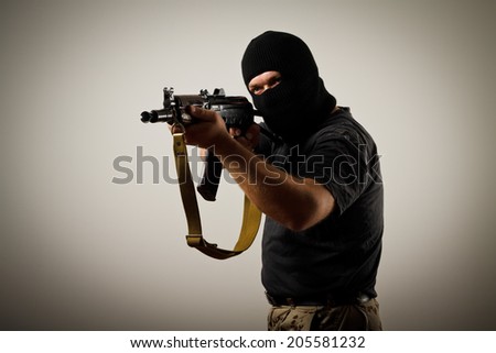 Man in mask with gun. Russian terrorist with Kalashnikov rifle.