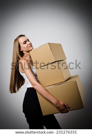 Woman holding a pile of packaged parcels. Woman is doing something. Carton.