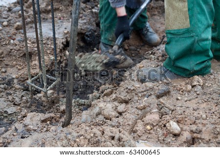 A construction workers digging with a shovel