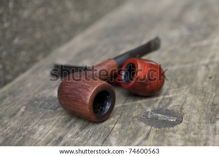 Two tobacco pipes on the wooden bench