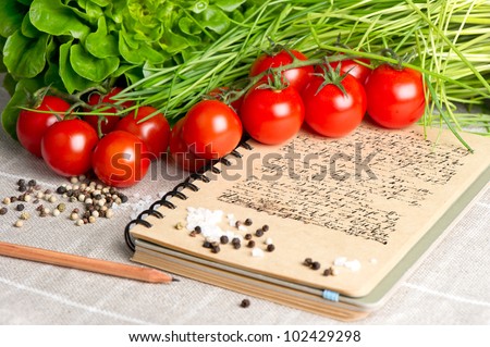 open vintage cook book  with old recipe text. vegetables tomato, chives and spices