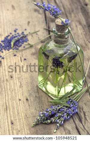 essential herbal lavender oil with fresh flowers on wooden background