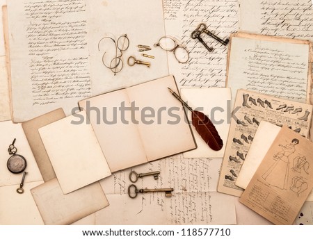 vintage accessories and open book with old letters. nostalgic fashion background