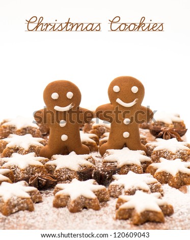 gingerbread man cookie, cinnamon stars and star anise on wooden background. christmas bakery