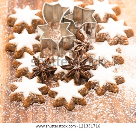 cinnamon stars and star anise on wooden background with sugar powder. christmas bakery