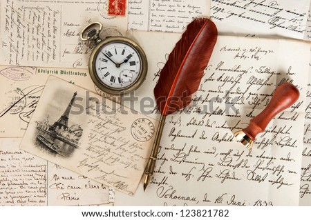 old letters, french post cards, antique feather pen and watch. nostalgic vintage background