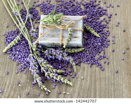 herbal soap and bath salt with fresh lavender flowers over wooden background. selective focus