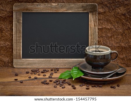cup of coffee and antique blackboard for your text. coffee leaves and beans