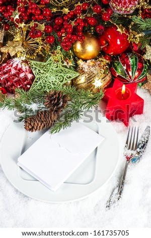 festive christmas table place setting decoration in red and gold. candle light dinner