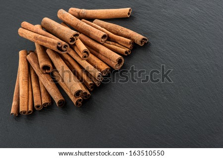 cinnamon sticks on black stone plate background. spice. food ingredient
