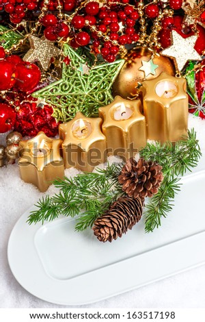 festive christmas table place setting decoration in red, green, gold. advent candle light dinner
