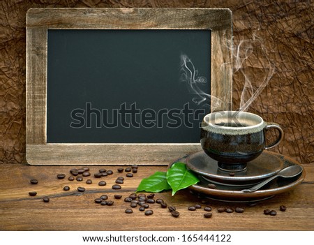 cup of coffee and vintage style blackboard for your text. still life with coffee leaves and beans