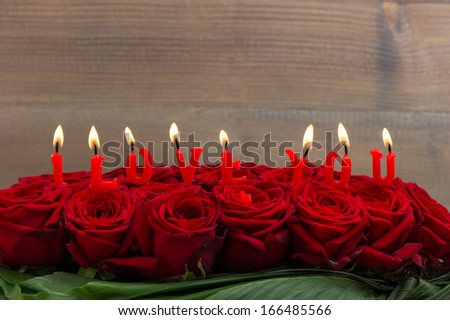 red roses and burning candles making I love you. Festive flower arrangement. selective focus