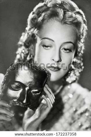 GERMANY, BERLIN - CIRCA 1938: portrait of young woman with a carnival mask. art deco. vintage photograph. Illustrative Image, subject of human interest. original film grain