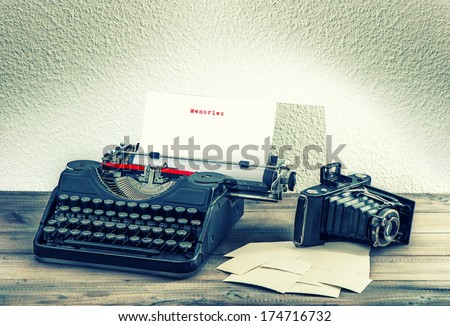 old mechanical typewriter and vintage photo camera on wooden background. antique objects. memories concept