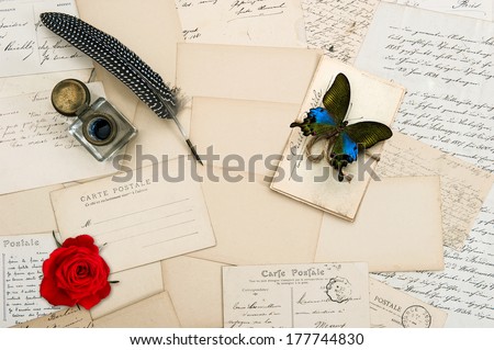 old love letters, handwritings, vintage postcards and antique feather pen. nostalgic sentimental background with butterfly and red rose flower