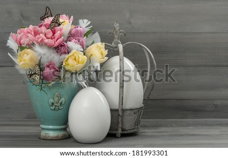 pastel colored tulip flowers with vintage easter eggs decoration. retro style toned picture. antique objects