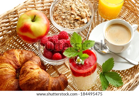Breakfast with coffee, croissants, orange juice and fresh strawberry yogurt