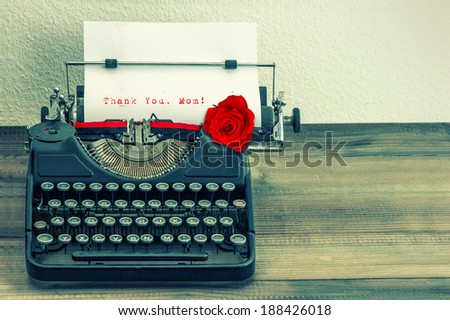 vintage typewriter with white page and red rose flower. sample text Thank You, Mom! Mother\'s Day concept. retro style toned picture