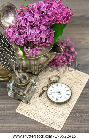lilac flowers and old post mail on wooden background. retro style toned picture.