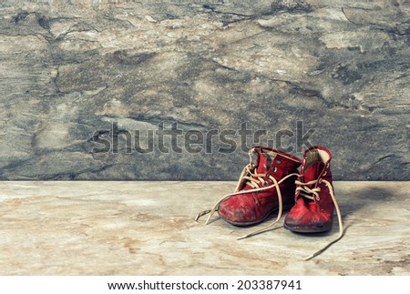 vintage red baby shoes over rustic background. retro style toned picture