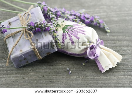 lavender soap and scented sachets with fresh flowers over wooden background