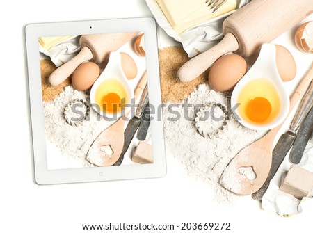 notebook tablet pc and baking ingredients eggs, flour, sugar, butter, yeast. taking food photos with digital tablet pc
