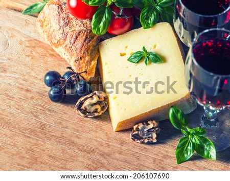 cheese with red wine and walnuts. food and beverages. retro style toned picture. selective focus