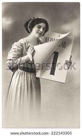 young woman with New Years calendar. antique picture with original scratches and film grain