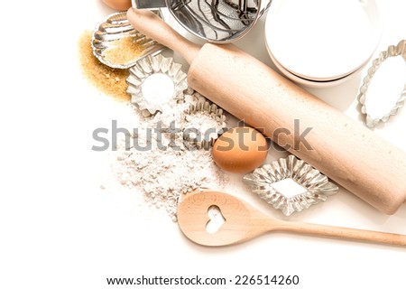 baking tools and ingredients. flour, eggs, sugar, rolling pin and cookie cutters on white background