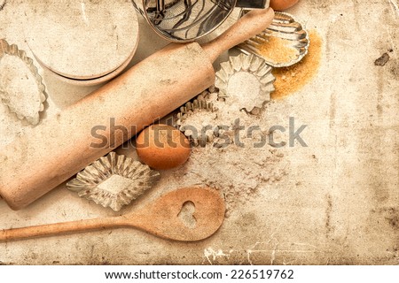 baking ingredients and tolls for dough preparation. flour, eggs, sugar, rolling pin and cookie cutters on white background. retro style picture