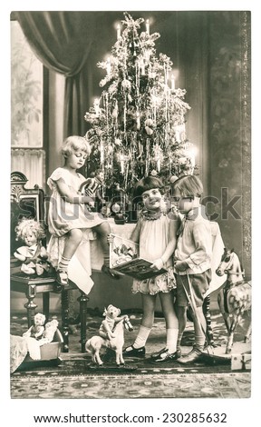 happy kids with christmas tree, gifts and vintage toys. antique sepia picture with original film grain