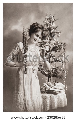 young woman with christmas tree and gifts. antique picture with original scratches and film grain