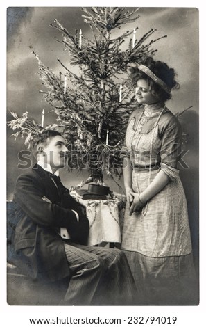 happy young couple celebrated with christmas tree. vintage picture with original film grain and blur