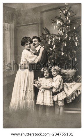 victorian family parents and children with christmas tree . vintage picture with original film grain and blur