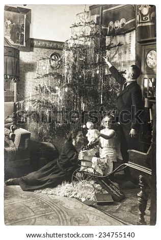 vintage family portrait of parents and child with christmas tree. antique picture with original film grain and blur. black and white photo