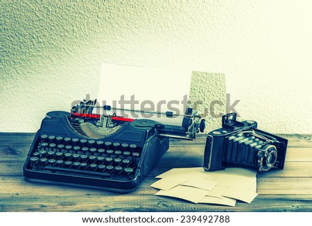 old typewriter and vintage photo camera on wooden background. retro style toned picture