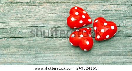 Three Red Hearts On Wooden Background. Lovely Valentines Day Decoration. Retro style toned picture