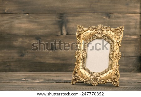 antique golden picture frame on rustic wooden background